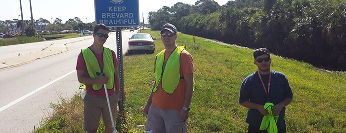 3 young men picking up trash on Barnes Blvd.