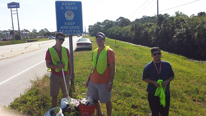 3 young men picking up trash on Barnes Blvd.