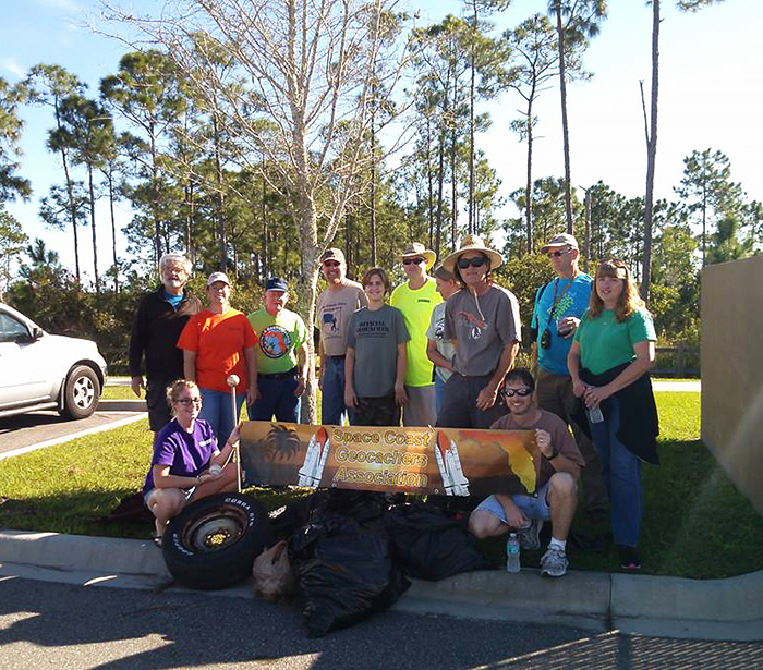 Group of Space Coast GeoCachers posing with trash picked up at Max Rodes Park in W. Melbourne